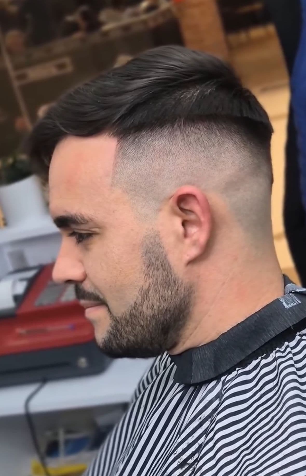Exterior of the barbershop with elegant gold lettering on a black facade.